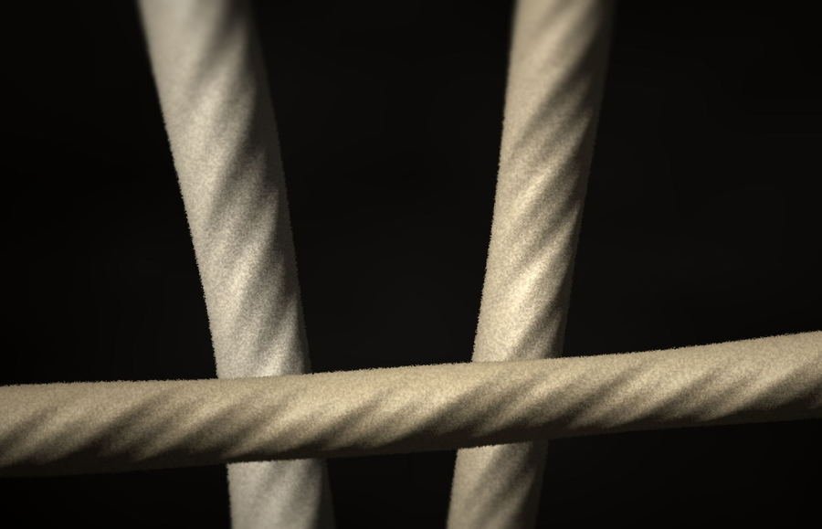 Macro view of spun cotton yarn showing the helical twist and stray surface fibres.